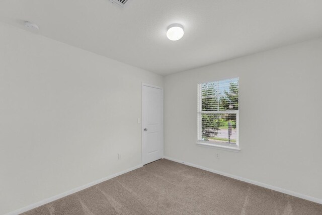 608 Silver Wing Dr, Austin, TX 78725 - empty room with light carpet and a smoke detector
