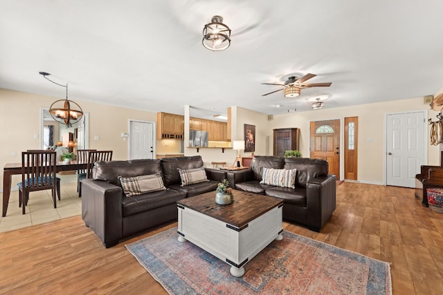 11551 Fm 32, Fischer, TX 78623 - living room featuring ceiling fan, light wood-style flooring, and a chandelier