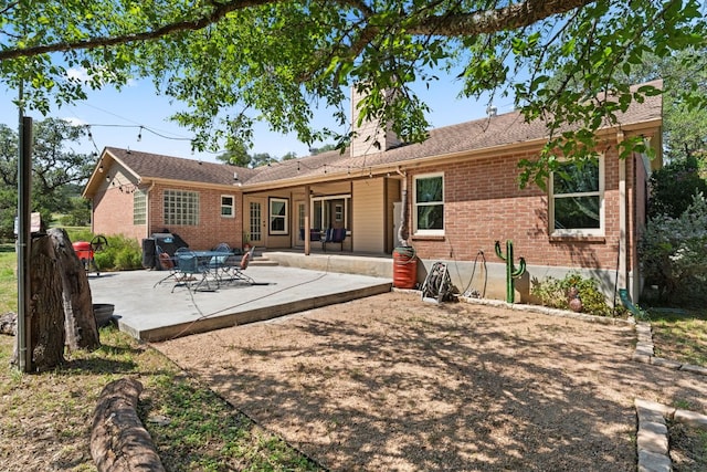 11551 Fm 32, Fischer, TX 78623 - rear view of property featuring brick siding, a patio, and a chimney