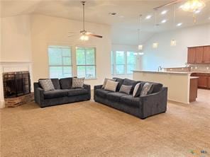 5413 Sandstone Dr, Temple, TX 76502 - living room with light colored carpet, a ceiling fan, vaulted ceiling, and a brick fireplace