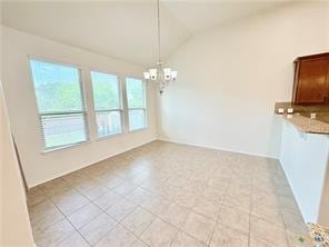 5413 Sandstone Dr, Temple, TX 76502 - unfurnished dining area with vaulted ceiling and a chandelier