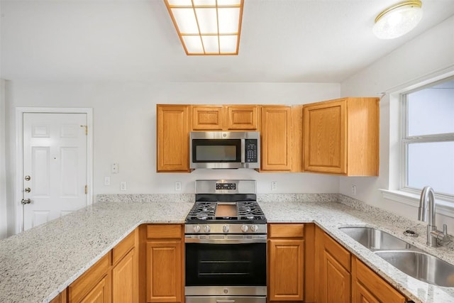 613 Broken Bow Dr, Round Rock, TX 78681 - kitchen featuring appliances with stainless steel finishes, light stone countertops, and brown cabinetry
