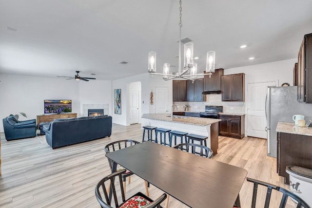 1310 Daniel Dr, Belton, TX 76513 - dining area with a ceiling fan, light wood-style flooring, a chandelier, a fireplace, and recessed lighting