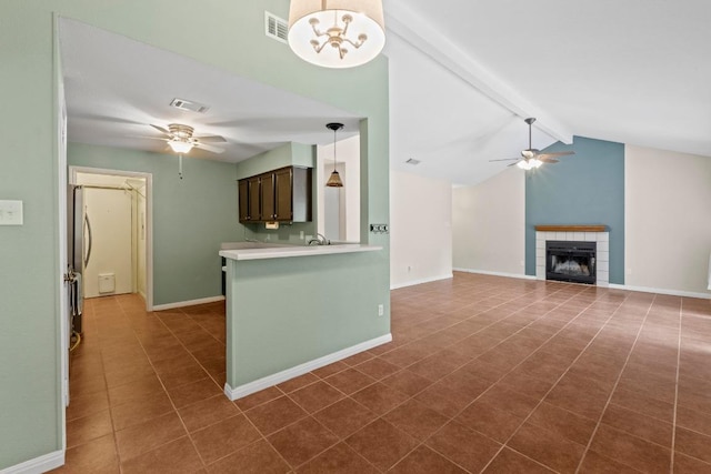 13402 Briar Hollow Dr, Austin, TX 78729 - kitchen with a ceiling fan, light countertops, a fireplace, dark brown cabinets, and dark tile patterned floors