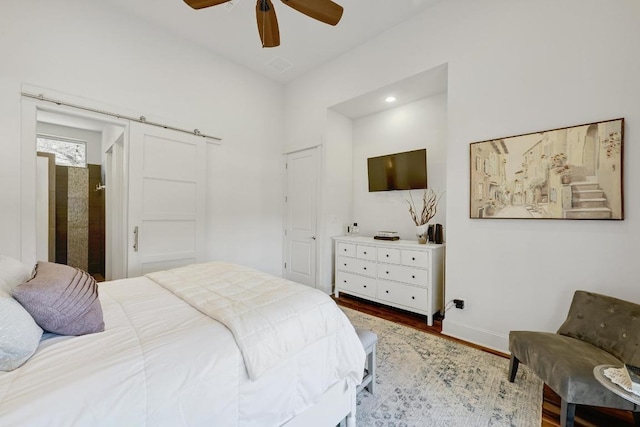 10129 Longhorn Skwy, Dripping Springs, TX 78620 - bedroom featuring wood finished floors, ceiling fan, a barn door, and recessed lighting