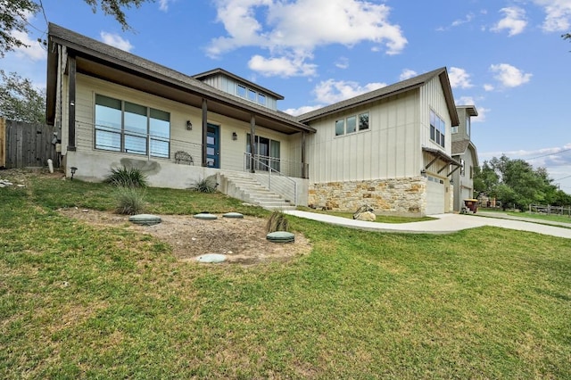 10129 Longhorn Skwy, Dripping Springs, TX 78620 - view of front of home with stone siding, concrete driveway, an attached garage, and board and batten siding