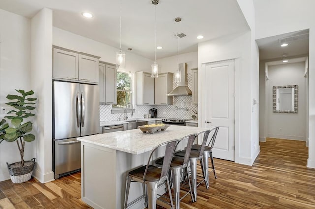 10129 Longhorn Skwy, Dripping Springs, TX 78620 - kitchen featuring stainless steel appliances, wall chimney exhaust hood, wood finished floors, backsplash, and recessed lighting