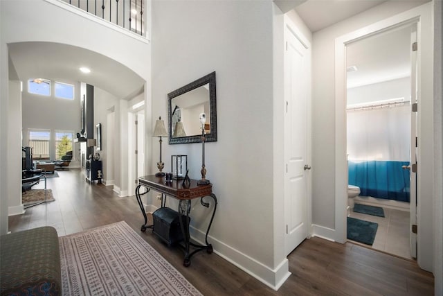 1113 Spring Gulch Ln, Georgetown, TX 78628 - hallway with arched walkways, dark wood-style floors, and a high ceiling