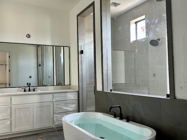 969 Tomichi Trl, Lakeway, TX 78738 - full bathroom with a soaking tub, vanity, tiled shower, and tile walls