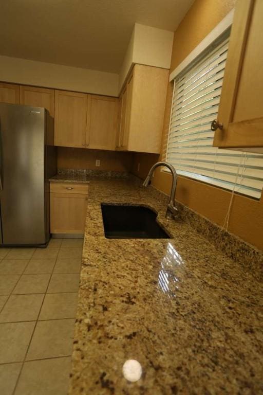 409-411 Cypress Ln, Round Rock, TX 78664 - kitchen featuring freestanding refrigerator, light stone counters, light brown cabinetry, and light tile patterned floors