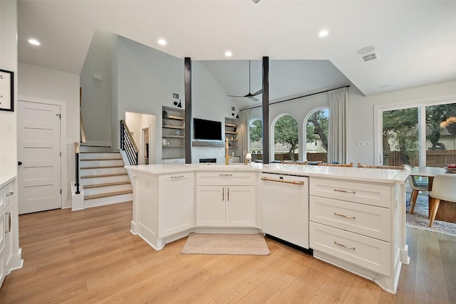 7308 Black Mountain Dr, Austin, TX 78736 - kitchen with white dishwasher, light countertops, white cabinets, light wood-style flooring, and lofted ceiling