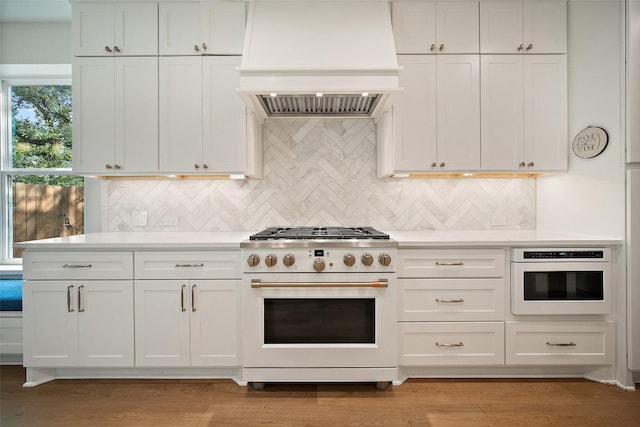 7308 Black Mountain Dr, Austin, TX 78736 - kitchen with range with gas cooktop, custom range hood, light countertops, and white cabinetry