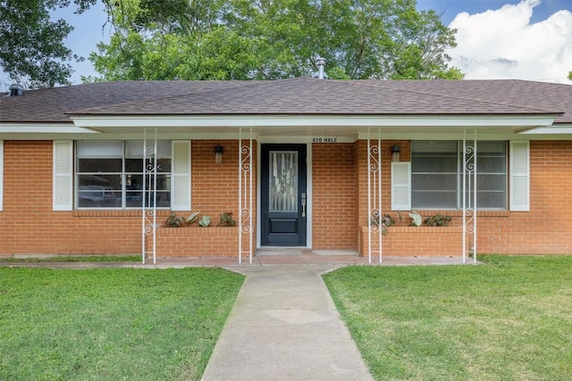 420 Hale St, Lexington, TX 78947 - view of front of house with a front yard, covered porch, brick siding, and roof with shingles