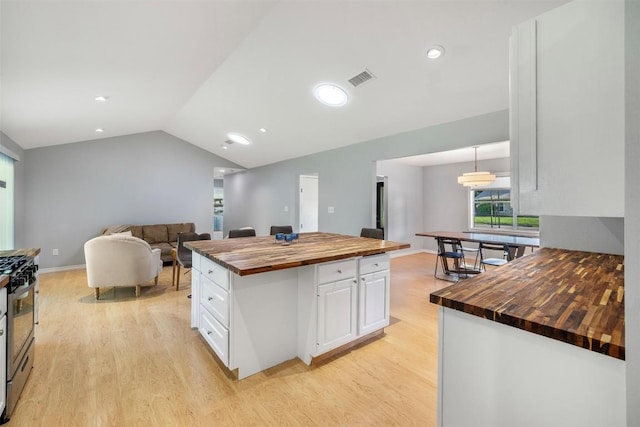 420 Hale St, Lexington, TX 78947 - kitchen with wooden counters, light wood-type flooring, white cabinetry, vaulted ceiling, and stainless steel gas range oven