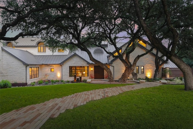 5301 Maryanna Dr, Austin, TX 78746 - view of front facade featuring stone siding, a standing seam roof, a front lawn, and a metal roof