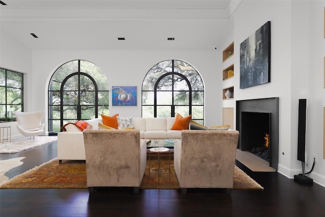 5301 Maryanna Dr, Austin, TX 78746 - living room featuring dark wood-style floors, built in shelves, and a fireplace with flush hearth