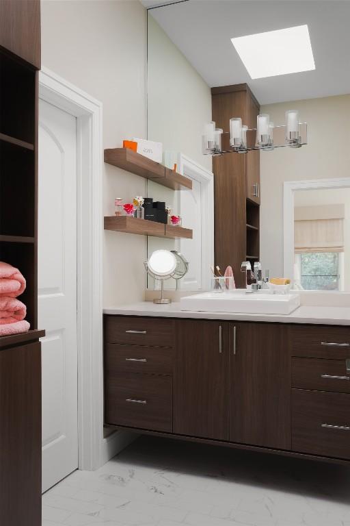5301 Maryanna Dr, Austin, TX 78746 - kitchen with marble finish flooring, a skylight, open shelves, and light countertops