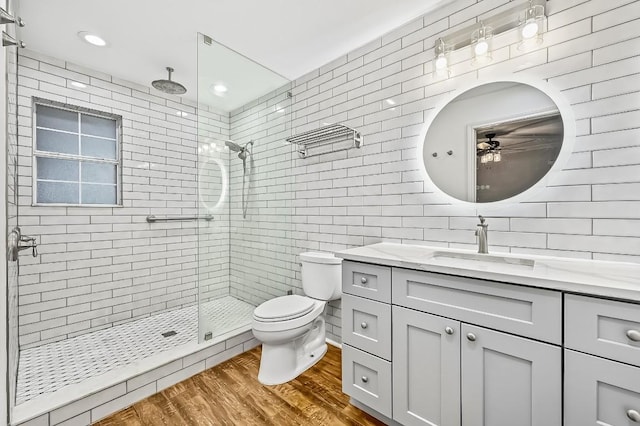 2802 Brandy Ln, Georgetown, TX 78628 - full bath featuring a ceiling fan, tile walls, vanity, a shower stall, and wood finished floors