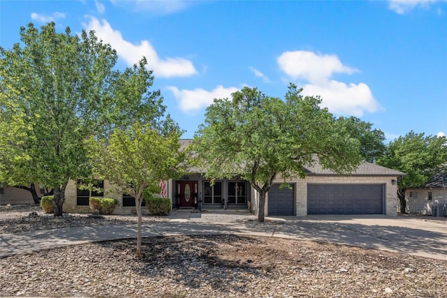 401 N Fox Xing, Burnet, TX 78611 - obstructed view of property featuring concrete driveway, a garage, and stone siding