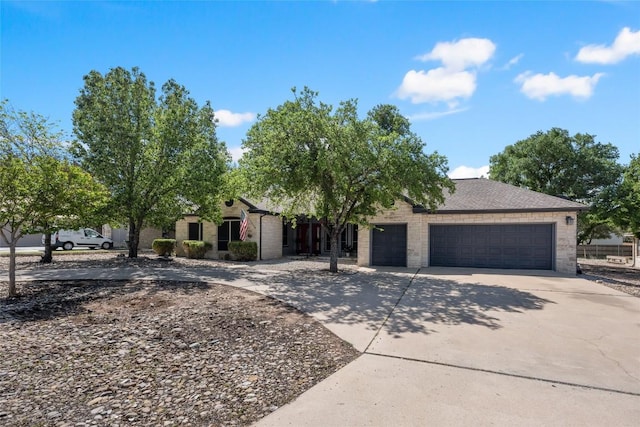 401 N Fox Xing, Burnet, TX 78611 - obstructed view of property featuring concrete driveway, a garage, and stone siding