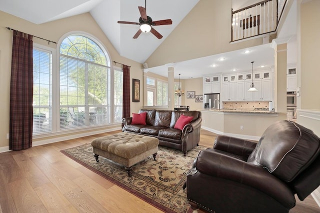 10008 Inshore Dr, Austin, TX 78730 - living room featuring ceiling fan, light wood finished floors, ornate columns, and high vaulted ceiling