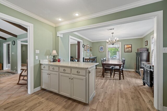 116 Ridgecrest Rd, Georgetown, TX 78628 - kitchen with a chandelier, light wood finished floors, ornamental molding, a peninsula, and hanging light fixtures