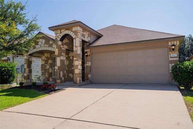11612 Yeadon Way, Austin, TX 78717 - view of front of home featuring stone siding, concrete driveway, a garage, and a shingled roof