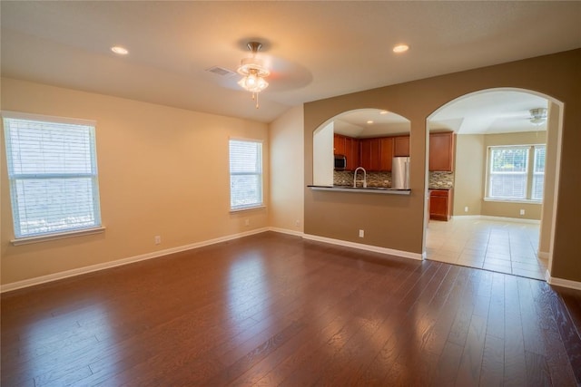 11612 Yeadon Way, Austin, TX 78717 - unfurnished living room with a ceiling fan, dark wood-style flooring, arched walkways, and recessed lighting