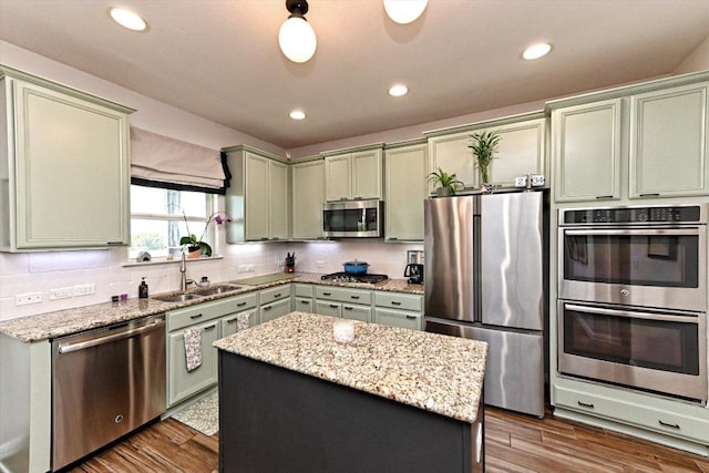 11600 Santa Elena Ln, Austin, TX 78717 - kitchen with stainless steel appliances, light stone counters, wood finished floors, green cabinetry, and recessed lighting