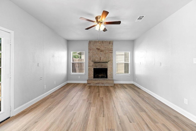 1207 York Castle Dr, Pflugerville, TX 78660 - unfurnished living room featuring light wood finished floors, ceiling fan, and a brick fireplace
