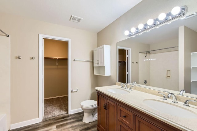 132 Hillhouse Ln, Manchaca, TX 78652 - full bath featuring wood finished floors, a shower, double vanity, and a walk in closet