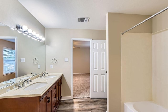 132 Hillhouse Ln, Manchaca, TX 78652 - full bathroom featuring wood finished floors, double vanity, and  shower combination