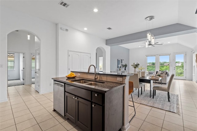 12221 Fairway Cv, Austin, TX 78732 - kitchen featuring arched walkways, light tile patterned flooring, a kitchen bar, recessed lighting, and open floor plan