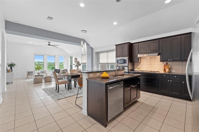 12221 Fairway Cv, Austin, TX 78732 - kitchen with stainless steel appliances, decorative backsplash, vaulted ceiling, light tile patterned flooring, and recessed lighting