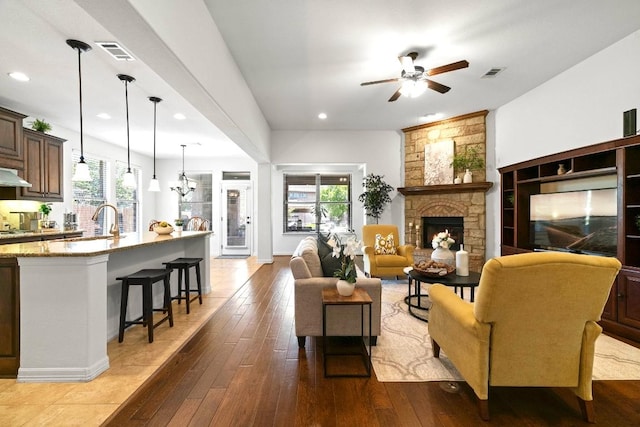139 Merion Dr, Austin, TX 78737 - living area featuring healthy amount of natural light, a ceiling fan, a stone fireplace, recessed lighting, and wood-type flooring