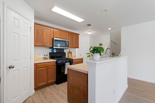 1431 Davis Mountain Loop, Cedar Park, TX 78613 - kitchen featuring stainless steel microwave, gas stove, light countertops, and light wood finished floors