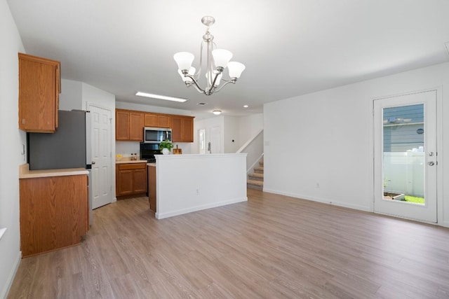 1431 Davis Mountain Loop, Cedar Park, TX 78613 - kitchen with stainless steel microwave, brown cabinets, light wood-style flooring, a chandelier, and open floor plan