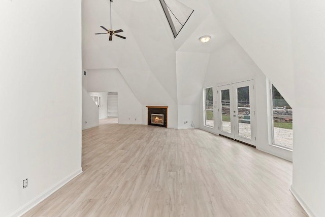 17226 Rocky Ridge Rd, Austin, TX 78734 - unfurnished living room featuring wood finished floors, ceiling fan, a warm lit fireplace, and high vaulted ceiling