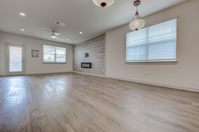 228 Tequilana Pass, Leander, TX 78641 - unfurnished living room with wood finished floors, a ceiling fan, a large fireplace, and recessed lighting