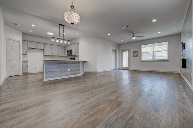 228 Tequilana Pass, Leander, TX 78641 - unfurnished living room with ceiling fan, wood finished floors, and recessed lighting