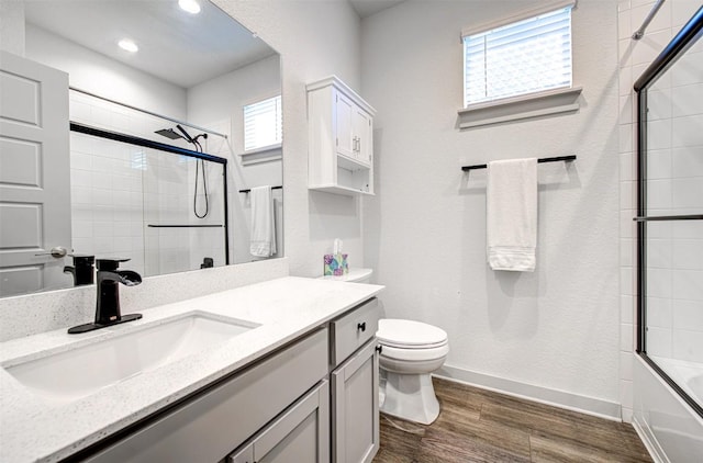 228 Tequilana Pass, Leander, TX 78641 - full bath featuring vanity, wood finished floors, shower / bath combination with glass door, and recessed lighting
