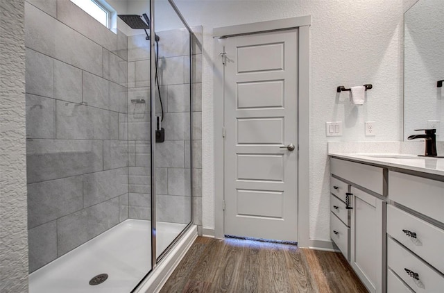 228 Tequilana Pass, Leander, TX 78641 - full bathroom with a stall shower, wood finished floors, vanity, and a textured wall
