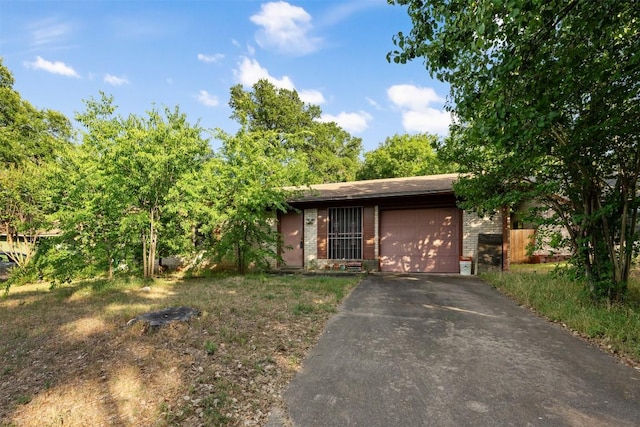 2329 Campden Dr, Austin, TX 78745 - view of front facade with asphalt driveway, brick siding, and an attached garage