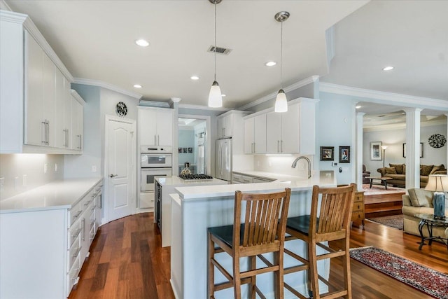 1208 Verdant Way, Austin, TX 78746 - kitchen with crown molding, a peninsula, fridge, dark wood-style floors, and white double oven