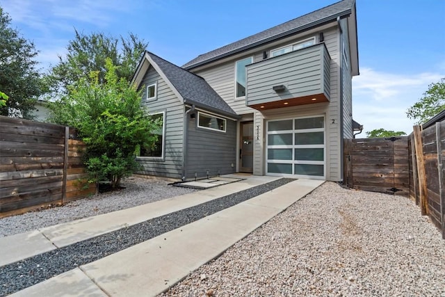 5006 Lott Ave Unit 2, Austin, TX 78721 - view of front of home featuring gravel driveway, a garage, a fenced backyard, and a shingled roof