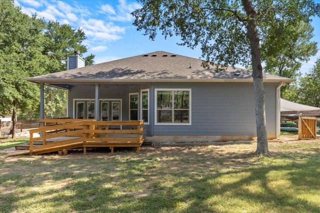 227 Kaelepulu Dr, Bastrop, TX 78602 - rear view of house with a chimney, a wooden deck, and roof with shingles