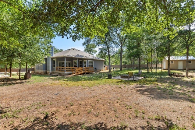 227 Kaelepulu Dr, Bastrop, TX 78602 - view of yard featuring a fire pit, a wooden deck, and a storage unit