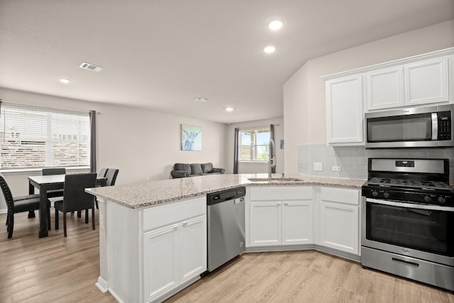 649 Otto Ave, Georgetown, TX 78626 - kitchen featuring stainless steel appliances, recessed lighting, a peninsula, white cabinets, and light wood-style floors