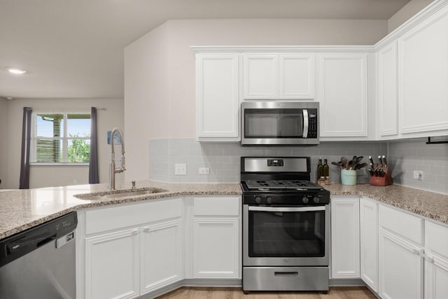 649 Otto Ave, Georgetown, TX 78626 - kitchen with appliances with stainless steel finishes, white cabinetry, decorative backsplash, and light stone countertops
