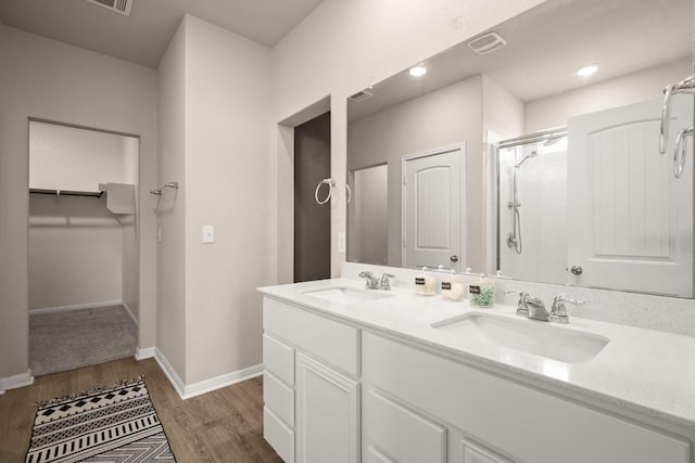 649 Otto Ave, Georgetown, TX 78626 - full bath featuring double vanity, an enclosed shower, wood finished floors, and a walk in closet